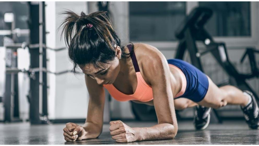 Woman working out at home using the BODi app on TV