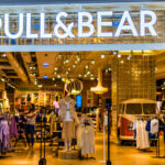 "Trendy Pull&Bear UK streetwear featuring oversized hoodies, wide-leg jeans, summer dresses and casual tops modeled by a diverse group."